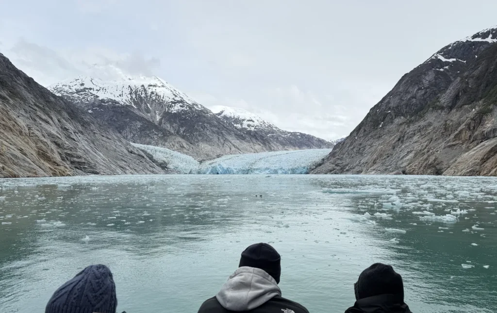 A couple people looking over the railing at the glacier ice field.