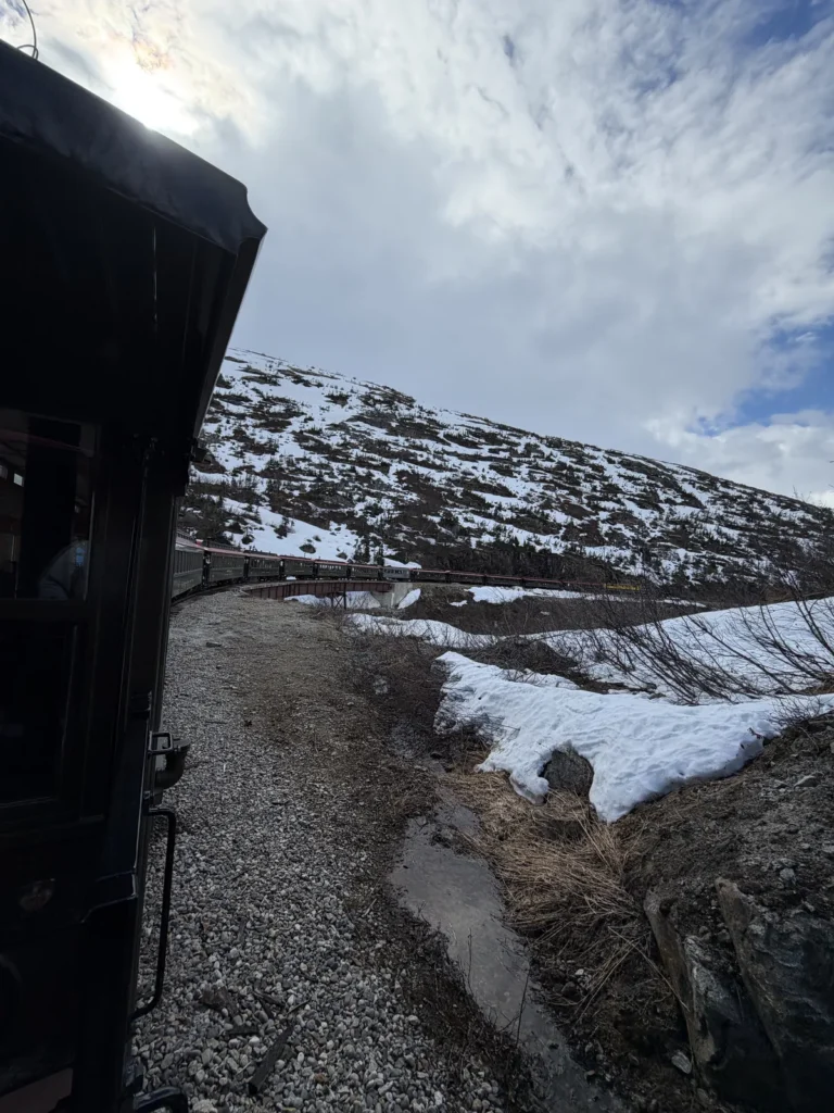 View of the White Pass Railroad train going around a bend in the tracks.