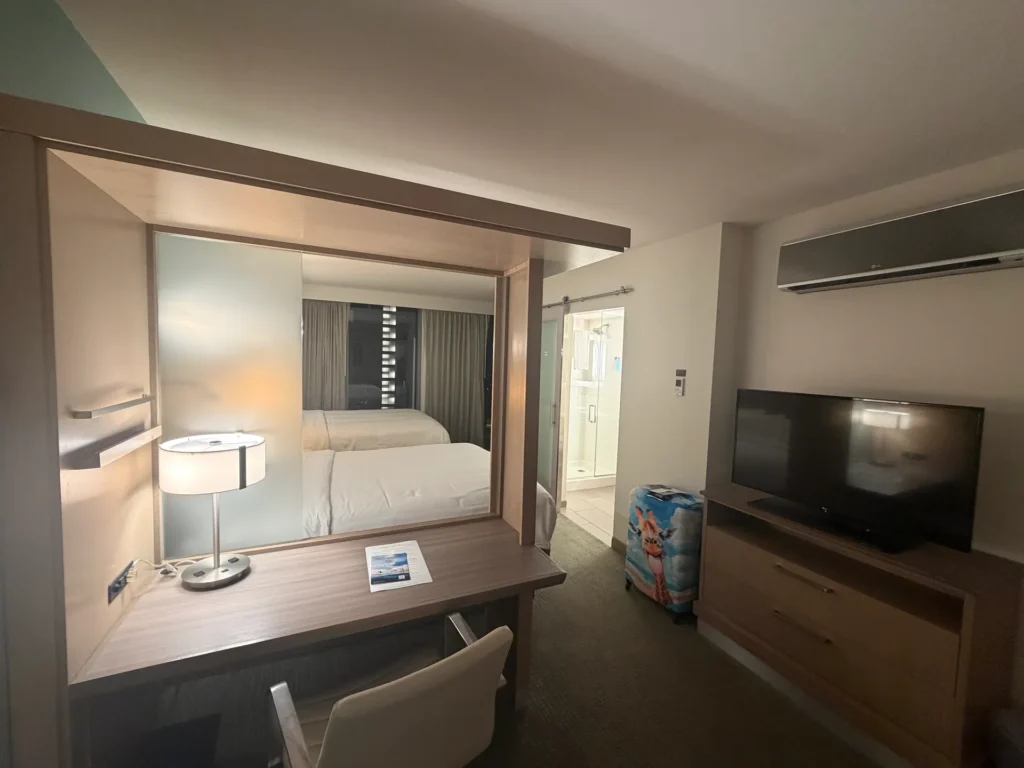 Desk with a frosted glass partition, TV, and sliding barn door to the bathroom at SpringHill Suites San Diego
